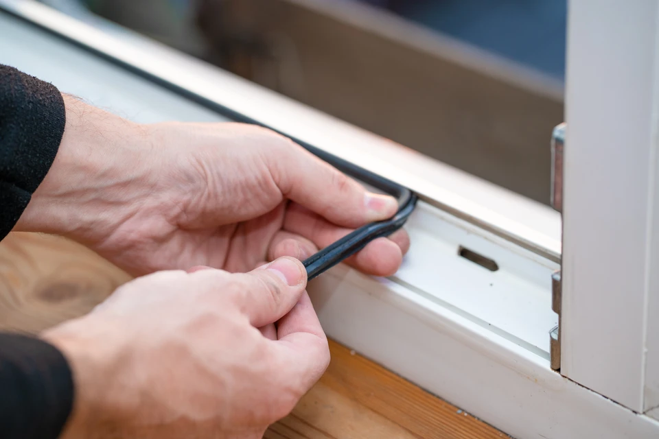 Maître professionnel pour la réparation et l'installation des fenêtres, change le joint de joint de joint en caoutchouc dans les fenêtres de pvc