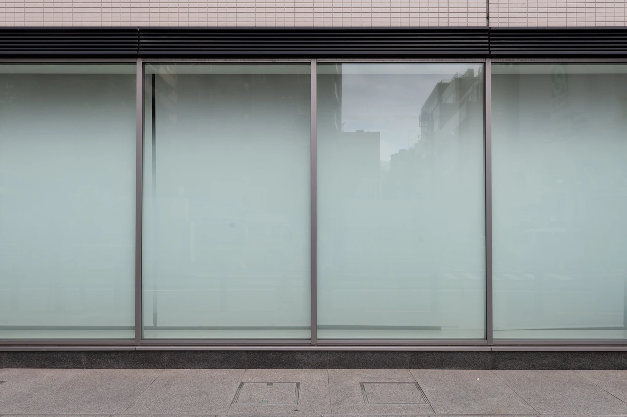 Grande façade vitrée moderne avec structure métallique et verre dépoli translucide