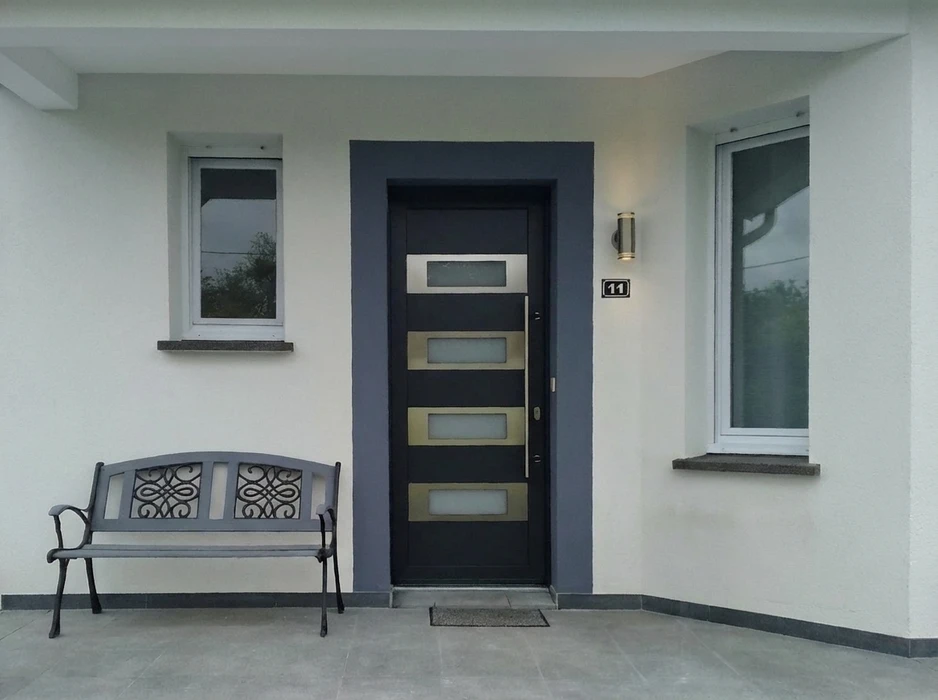 Entrée de maison moderne avec porte d'entrée blindée anthracite design contemporain, dotée de 4 inserts rectangulaires dorés avec vitrages dépolis et d'un vitrage supérieur