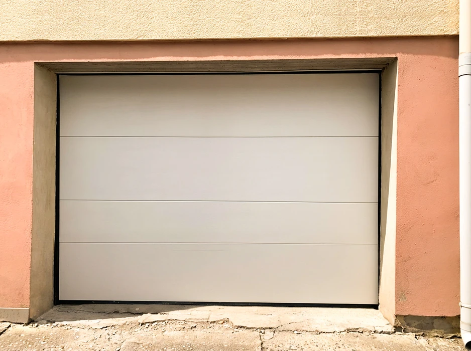 Porte de garage sectionnelle blanche, installation en applique intérieure dans une baie maçonnée