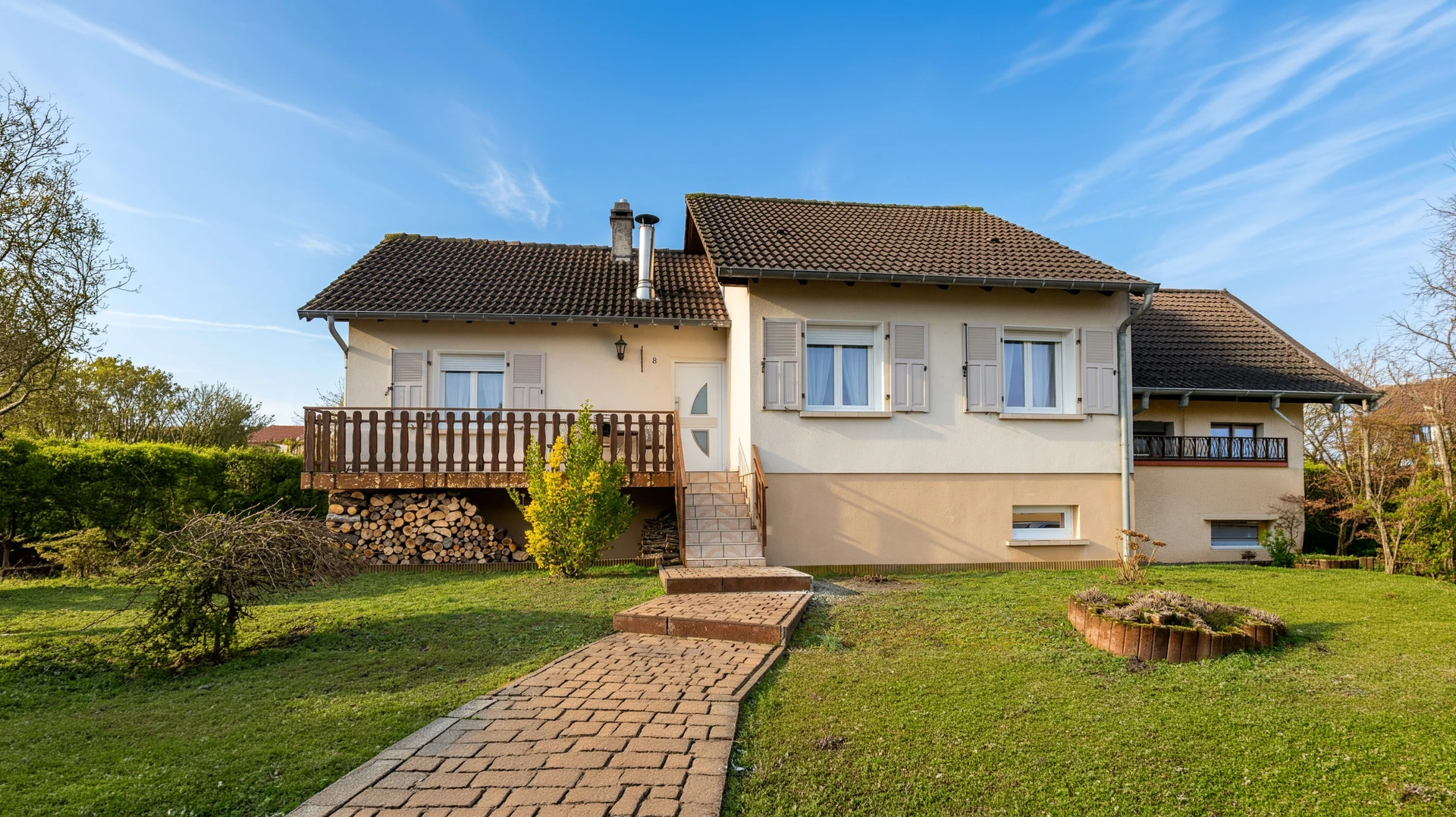 Entrée principale d'une maison moderne avec porte en bois massif à panneaux verticaux, imposte vitrée et baies latérales